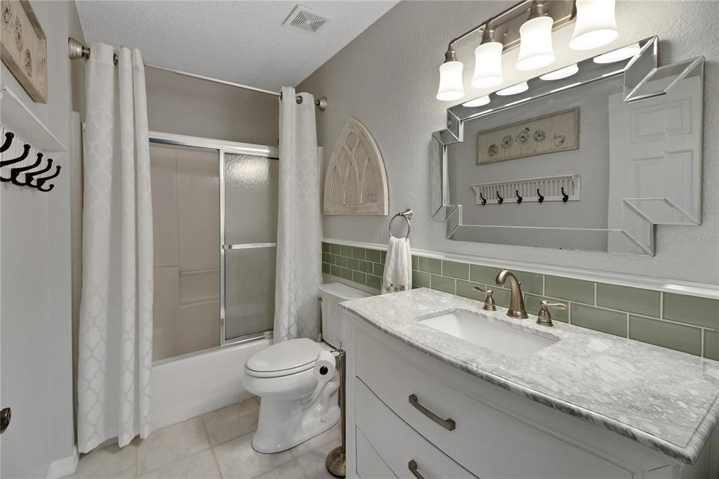 32801 Oak Park Drive Leesburg, FL 34748 - Photo 40 of 46 a bathroom with a granite countertop sink toilet a mirror and shower