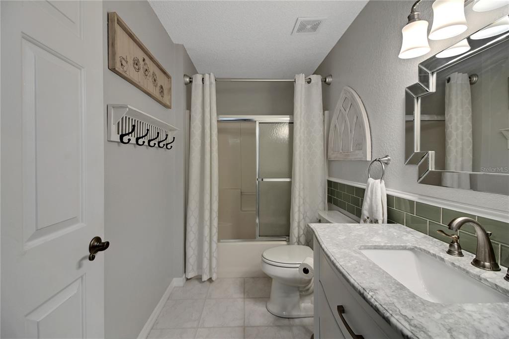 32801 Oak Park Drive Leesburg, FL 34748 - Photo 41 of 46 a bathroom with a granite countertop sink toilet and shower