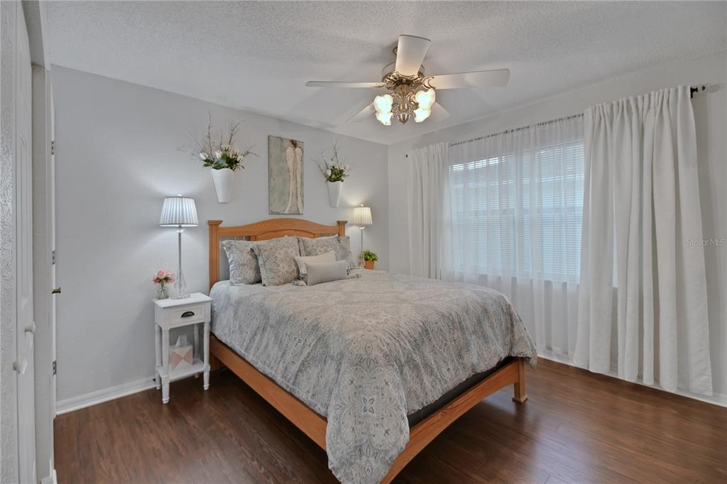 32801 Oak Park Drive Leesburg, FL 34748 - Photo 43 of 46 a spacious bedroom with a bed and a chandelier