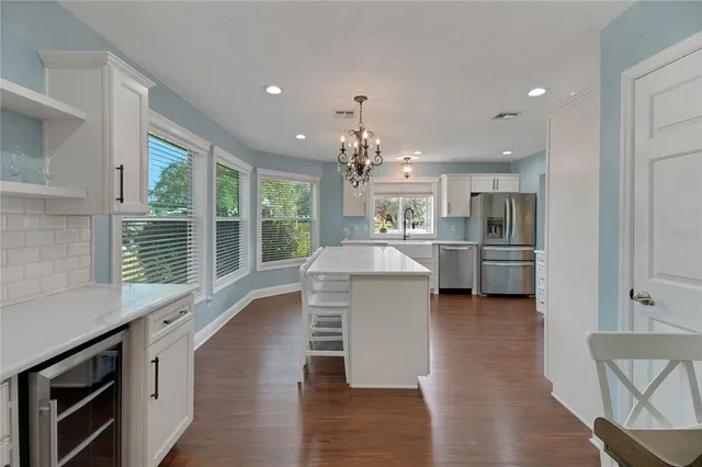 a spacious bathroom with a granite countertop sink a large mirror and a next to a window