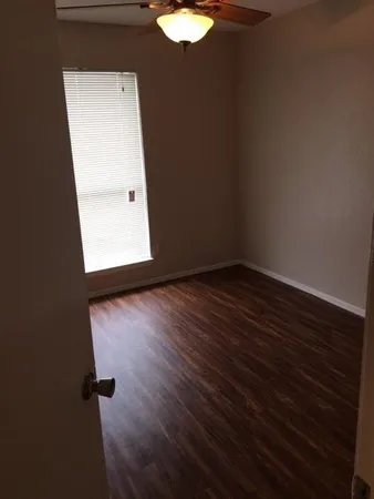 an empty room with wooden floor and mirror