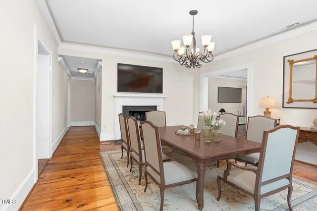 a view of a dining room with furniture a chandelier and wooden floor