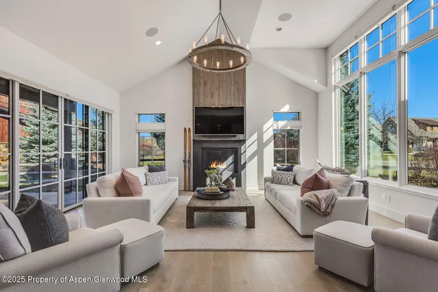 a living room with furniture white walls and kitchen view