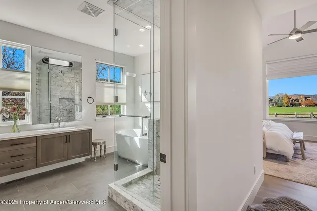 a living room with furniture a flat screen tv and a floor to ceiling window