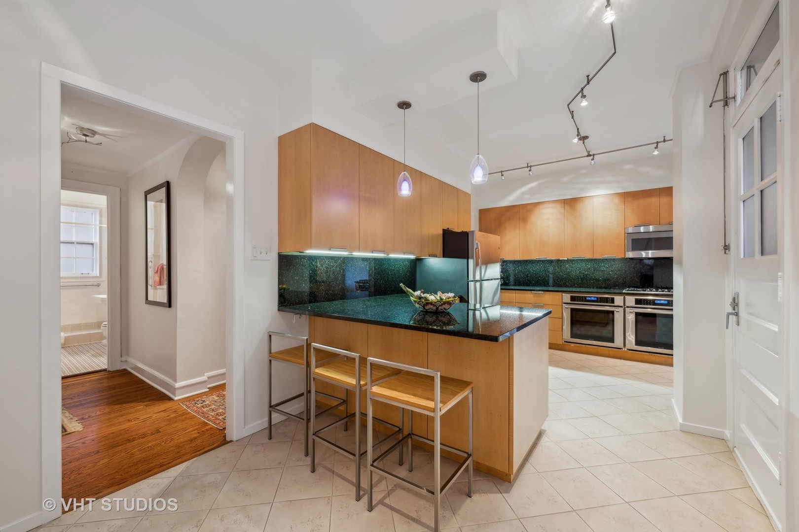 1426 Chicago Avenue, Unit 2N Evanston, IL 60201 - Photo 9 of 32 a kitchen with stainless steel appliances kitchen island granite countertop a table and chairs in it