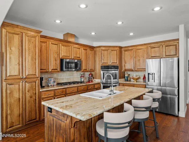 a kitchen with stainless steel appliances granite countertop a stove refrigerator sink and cabinets