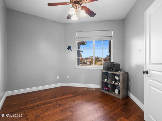 a view of workspace with wooden floor and ceiling fan