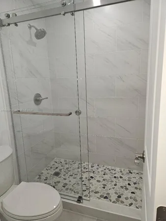a bathroom with a toilet and a shower