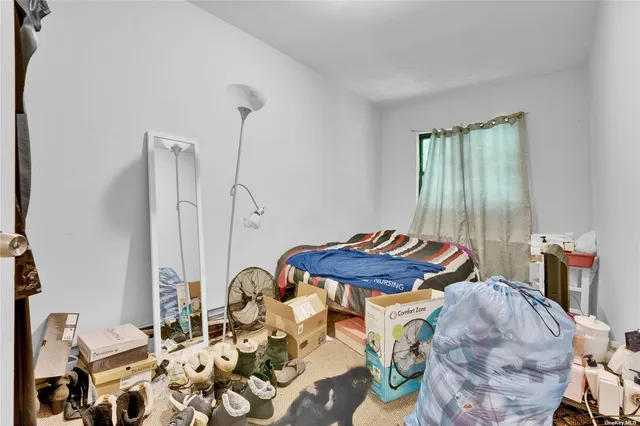 a bed sitting in a bedroom next to a window with wooden floor