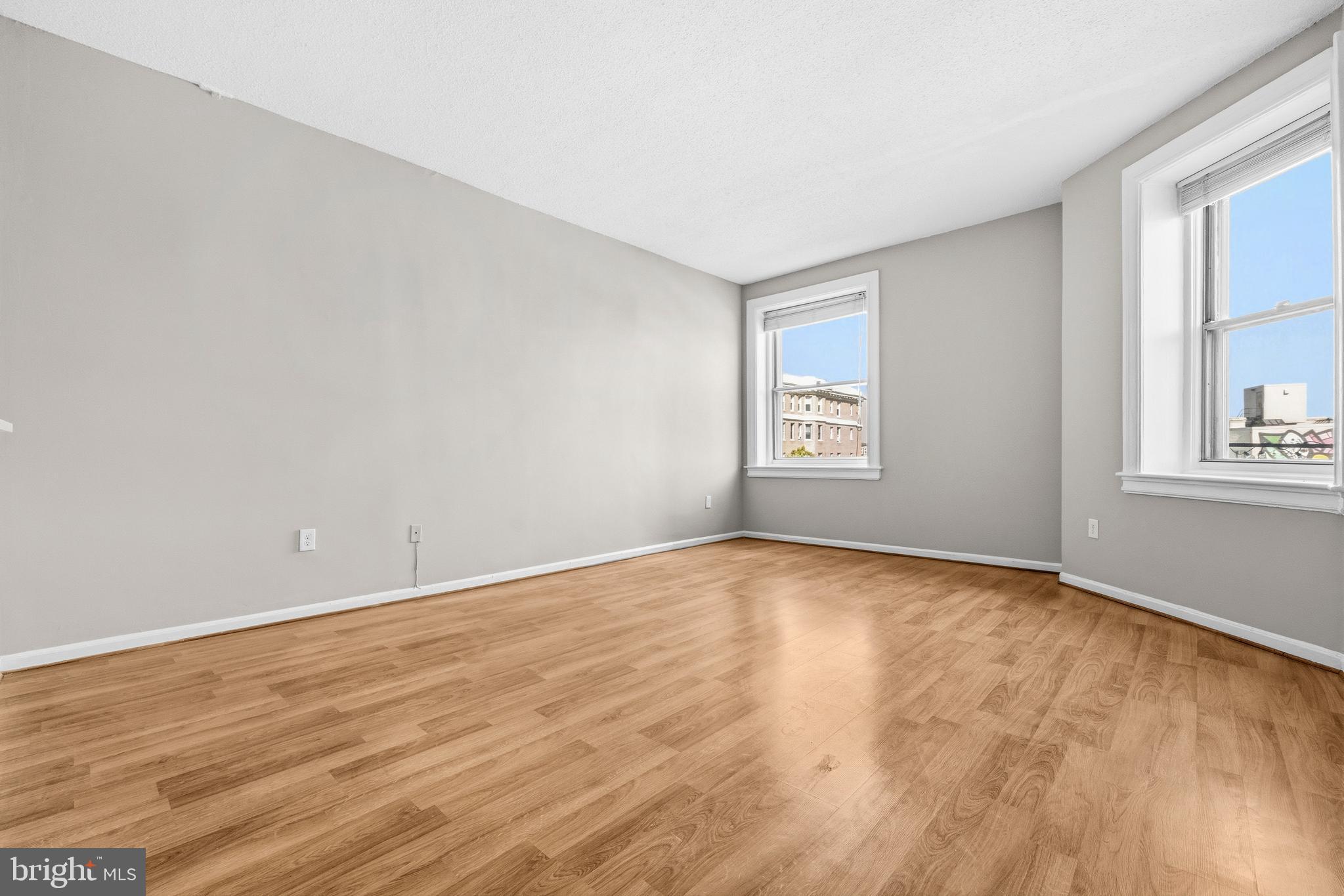 1851 Columbia Road Northwest, Unit 401 Washington, DC 20009 - Photo 4 of 27 a view of an empty room with a window and wooden floor