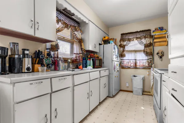 a kitchen with white cabinets and white appliances