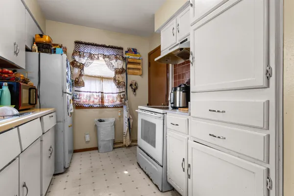 a kitchen with white cabinets and white appliances