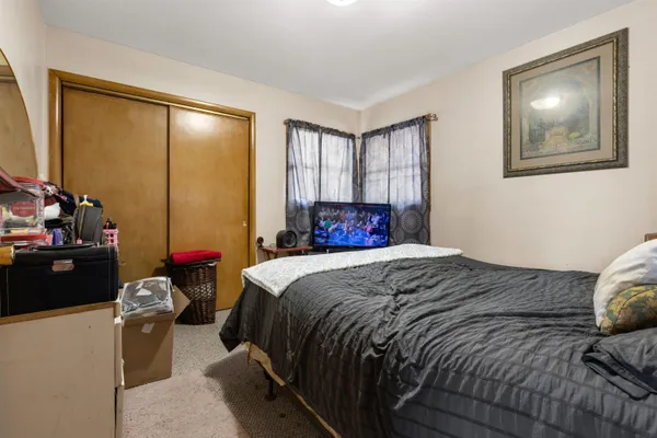 a bedroom with a bed and a painting on the wall