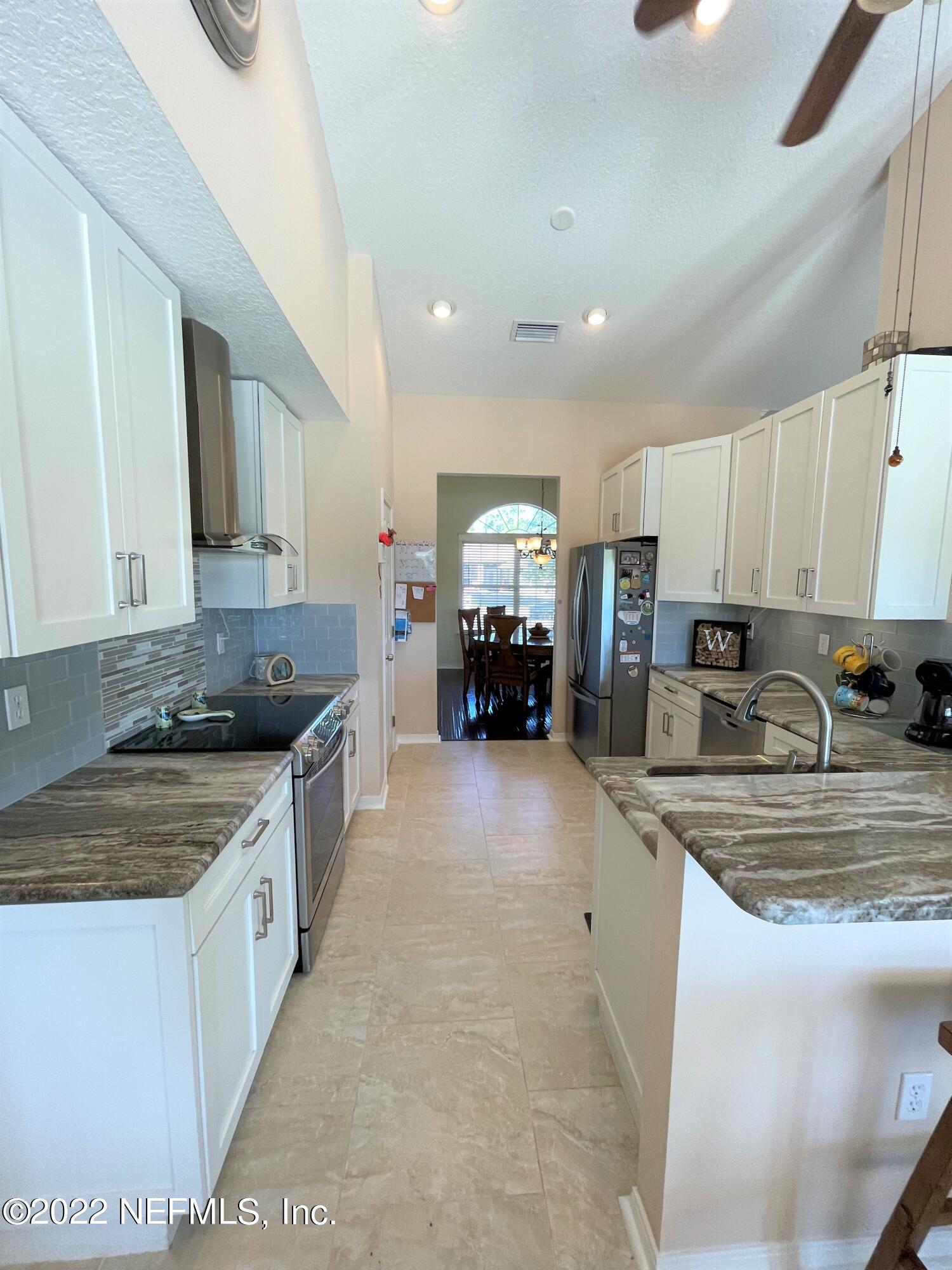 2867 Longleaf Ranch Circle Middleburg, FL 32068 - Photo 11 of 33 a large kitchen with stainless steel appliances granite countertop a stove a sink a refrigerator and a granite counter tops