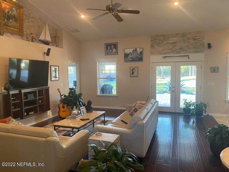 2867 Longleaf Ranch Circle Middleburg, FL 32068 - Photo 9 of 33 a living room with furniture a flat screen tv and a floor to ceiling window