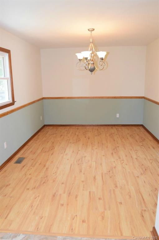 2112 Quail Ridge Road Monroe, NC 28110 - Photo 9 of 14 an empty room with a chandelier fan and wooden floor
