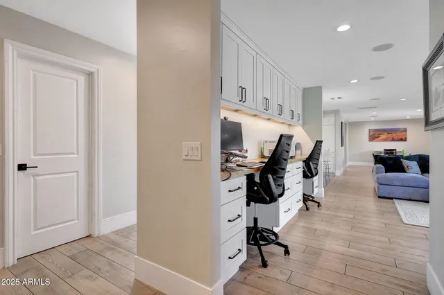 a view of a hallway with workspace and wooden floor