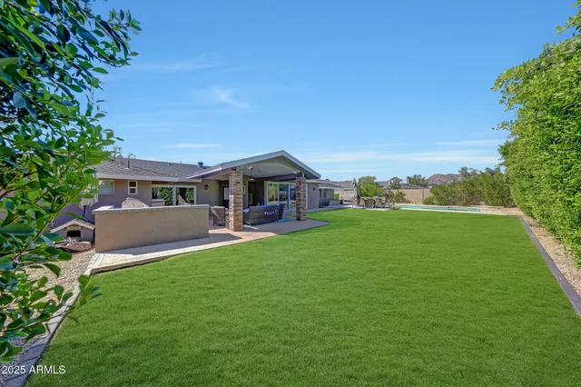 a view of house with swimming pool and yard