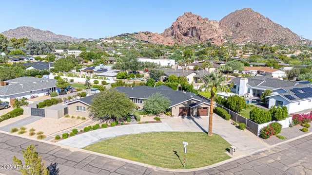 an aerial view of a house with a swimming pool a yard and lake view