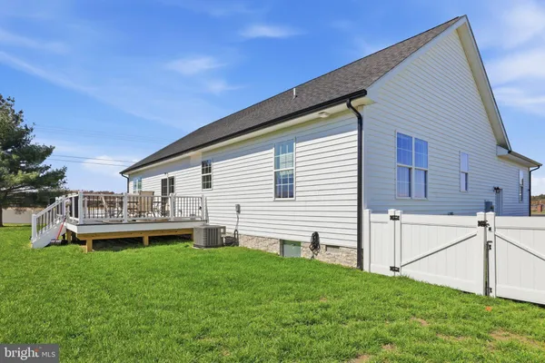a front view of house with a garden and deck