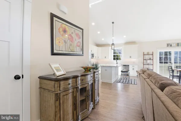 a living room with furniture a table and kitchen view
