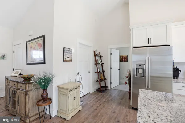 a living room with furniture and a refrigerator