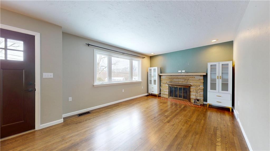 820 Sunset Drive Butler, PA 16001 - Photo 3 of 34 an empty room with wooden floor fireplace and windows