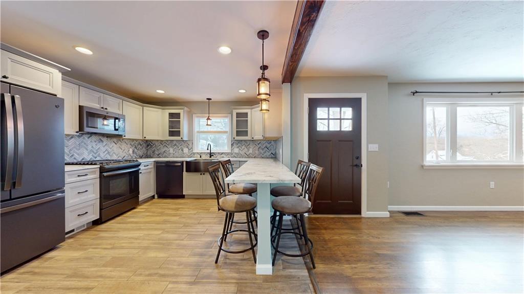 820 Sunset Drive Butler, PA 16001 - Photo 9 of 34 a open kitchen with stainless steel appliances granite countertop a stove top oven a sink dishwasher a dining table and chairs with wooden floor