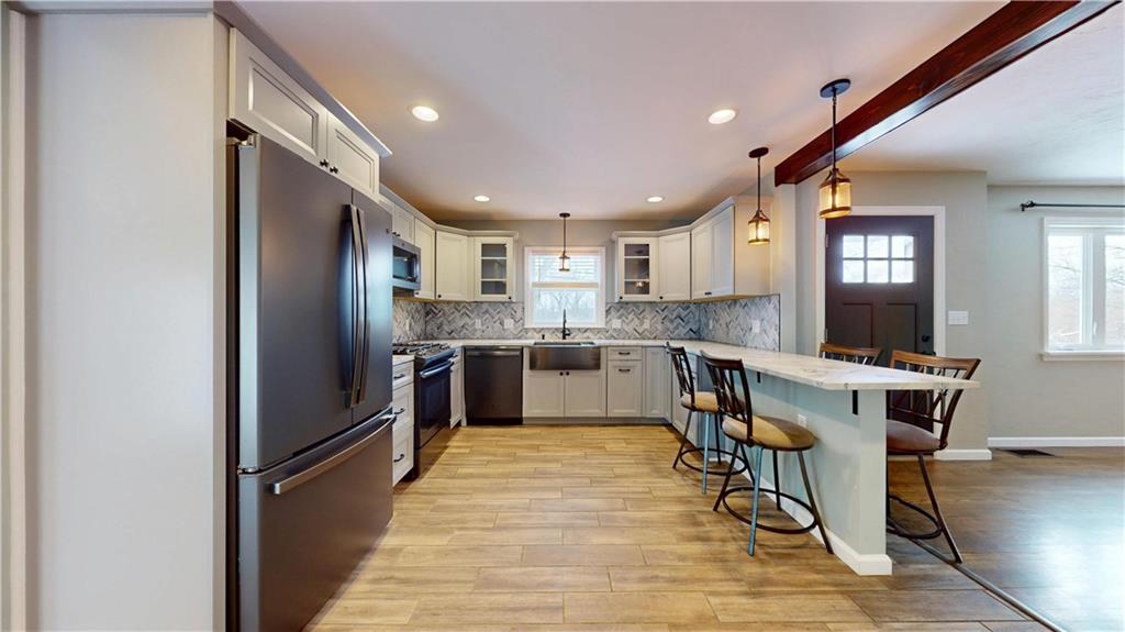 820 Sunset Drive Butler, PA 16001 - Photo 10 of 34 a kitchen with stainless steel appliances kitchen island granite countertop a refrigerator a stove a sink dishwasher a dining table and chairs with wooden floor