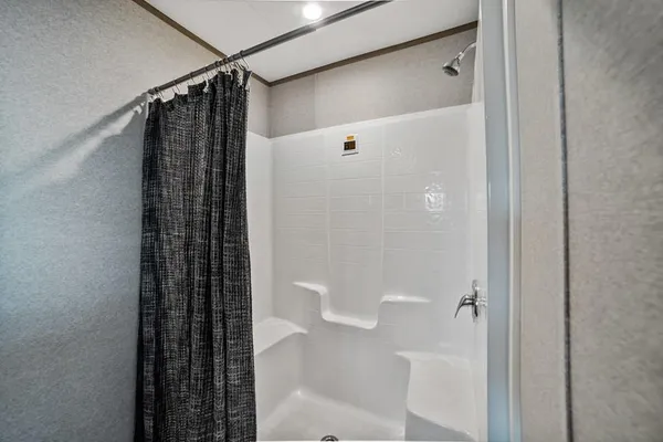 a bathroom with a shower and a glass door