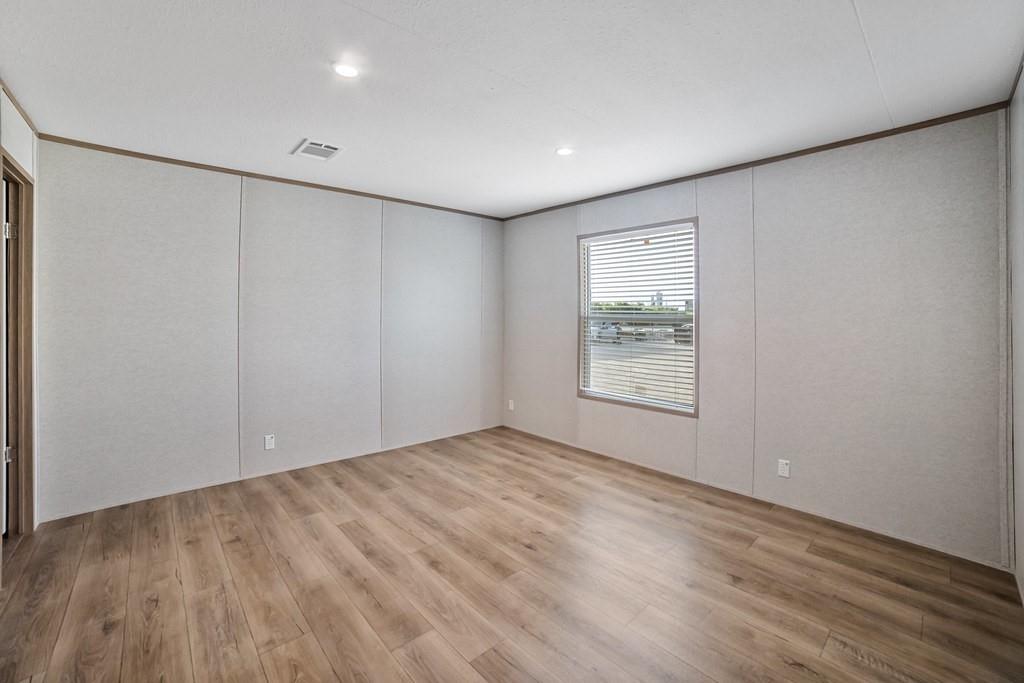 3106 Smyrna Road Sunset, TX 76270 - Photo 33 of 38 a view of an empty room with wooden floor and a window