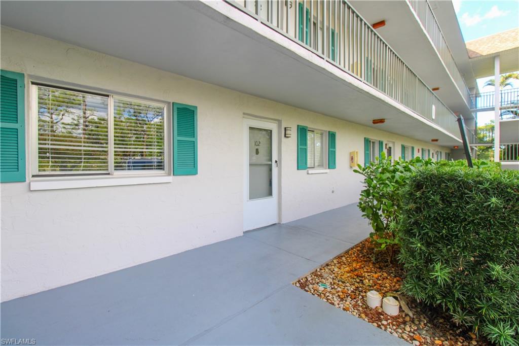 5635 Rattlesnake Hammock Road, Unit 102D Naples, FL 34113 - Photo 16 of 47 front view of a house with a yard