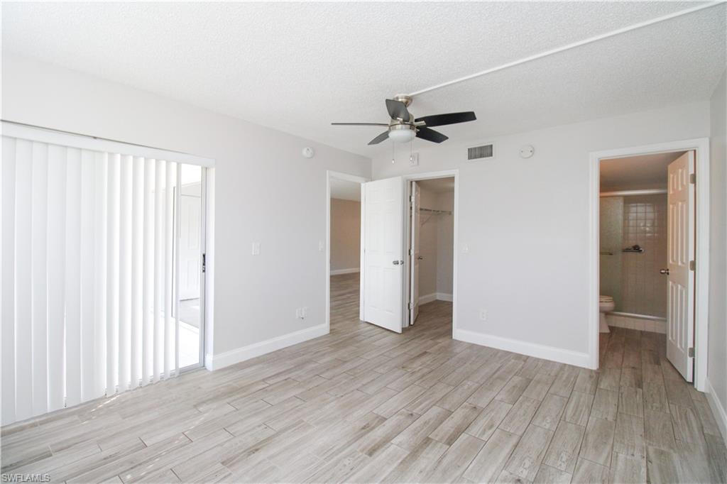 5635 Rattlesnake Hammock Road, Unit 102D Naples, FL 34113 - Photo 20 of 47 an empty room with wooden floor and windows