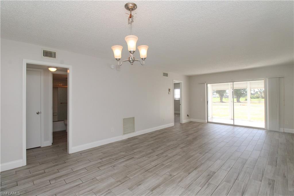 5635 Rattlesnake Hammock Road, Unit 102D Naples, FL 34113 - Photo 21 of 47 an empty room with wooden floor and windows