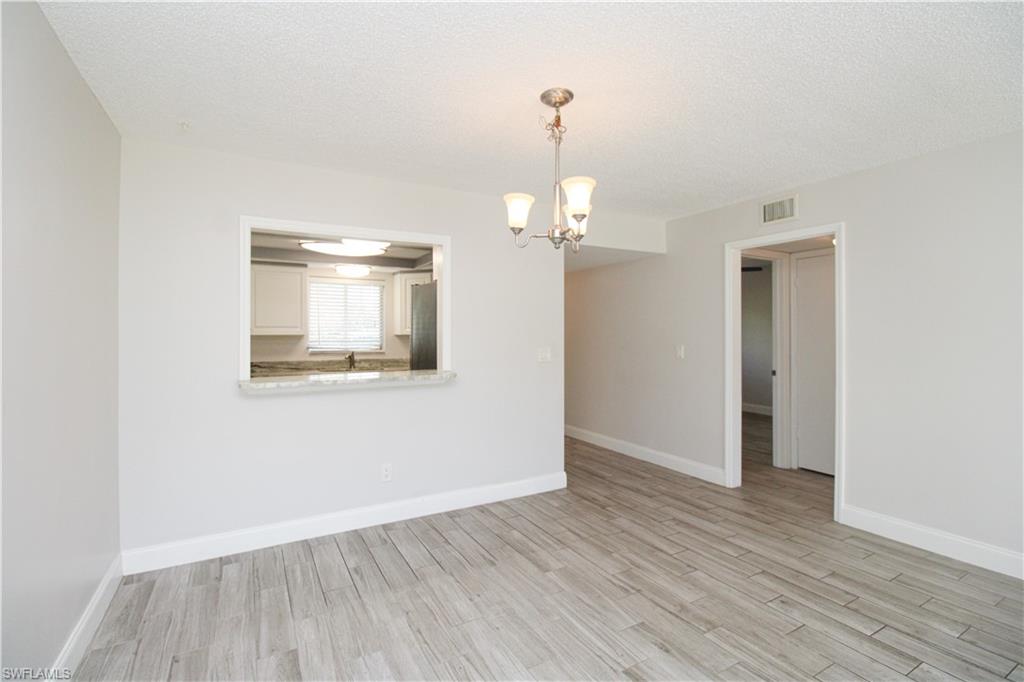 5635 Rattlesnake Hammock Road, Unit 102D Naples, FL 34113 - Photo 23 of 47 wooden floor in an empty room with a window
