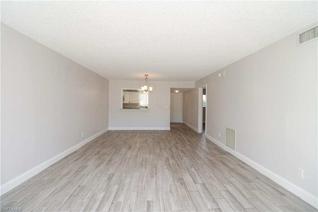 5635 Rattlesnake Hammock Road, Unit 102D Naples, FL 34113 - Photo 24 of 47 an empty room with wooden floor and windows