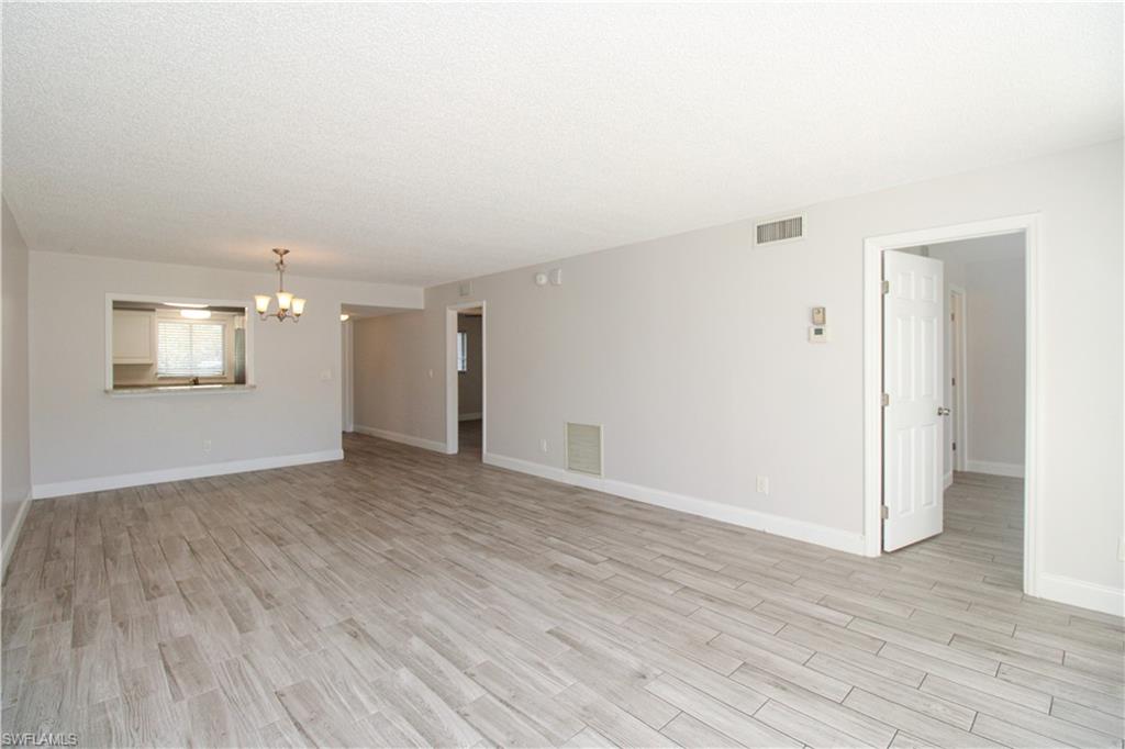 5635 Rattlesnake Hammock Road, Unit 102D Naples, FL 34113 - Photo 26 of 47 an empty room with wooden floor and windows