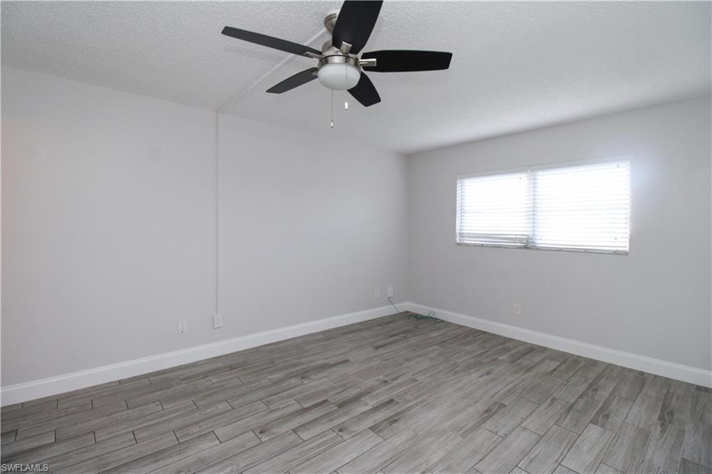 5635 Rattlesnake Hammock Road, Unit 102D Naples, FL 34113 - Photo 27 of 47 a view of an empty room with wooden floor and a window