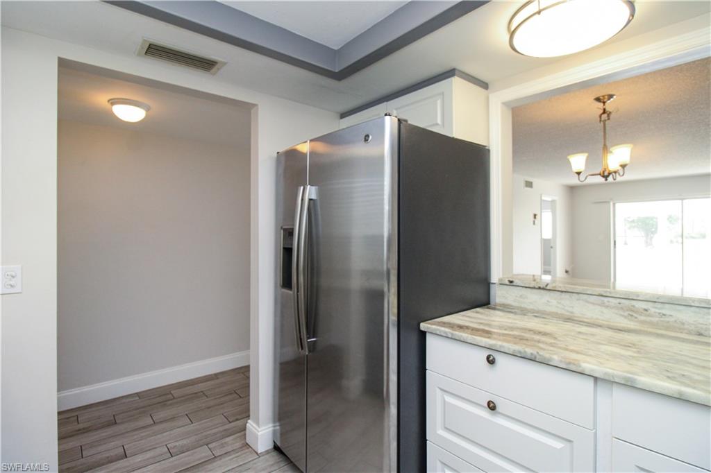 5635 Rattlesnake Hammock Road, Unit 102D Naples, FL 34113 - Photo 32 of 47 a bathroom with a granite countertop shower sink and mirror