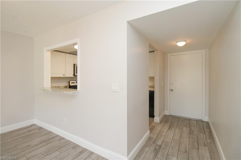 5635 Rattlesnake Hammock Road, Unit 102D Naples, FL 34113 - Photo 36 of 47 a view of a hallway with wooden floor