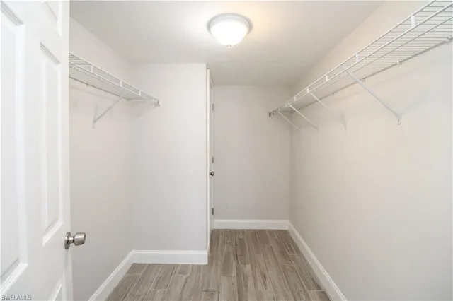 a view of a room with wooden floor and a window