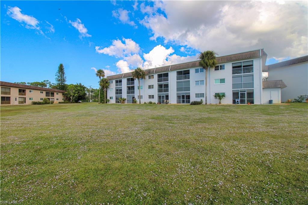 5635 Rattlesnake Hammock Road, Unit 102D Naples, FL 34113 - Photo 46 of 47 a view of a building with a yard