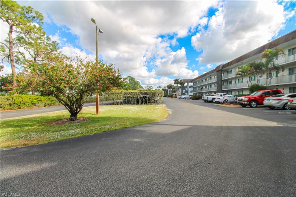 5635 Rattlesnake Hammock Road, Unit 102D Naples, FL 34113 - Photo 8 of 47 a view of a street with a building and a big yard