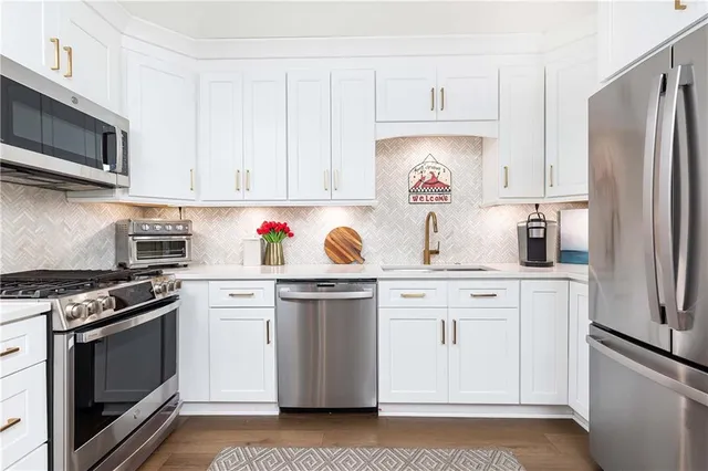 a kitchen with stainless steel appliances granite countertop a refrigerator stove top oven and sink with dishwasher
