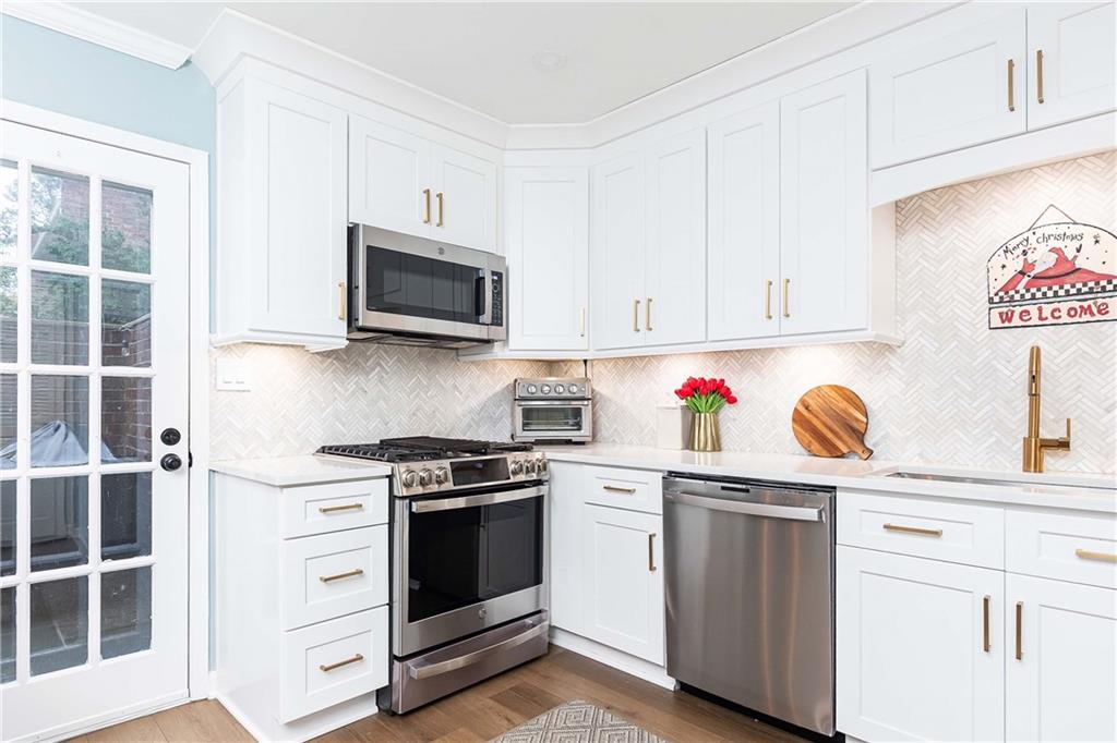 5 Middle Plantation Road Northwest, Unit 5 Atlanta, GA 30318 - Photo 13 of 33 a kitchen with granite countertop white cabinets and stainless steel appliances