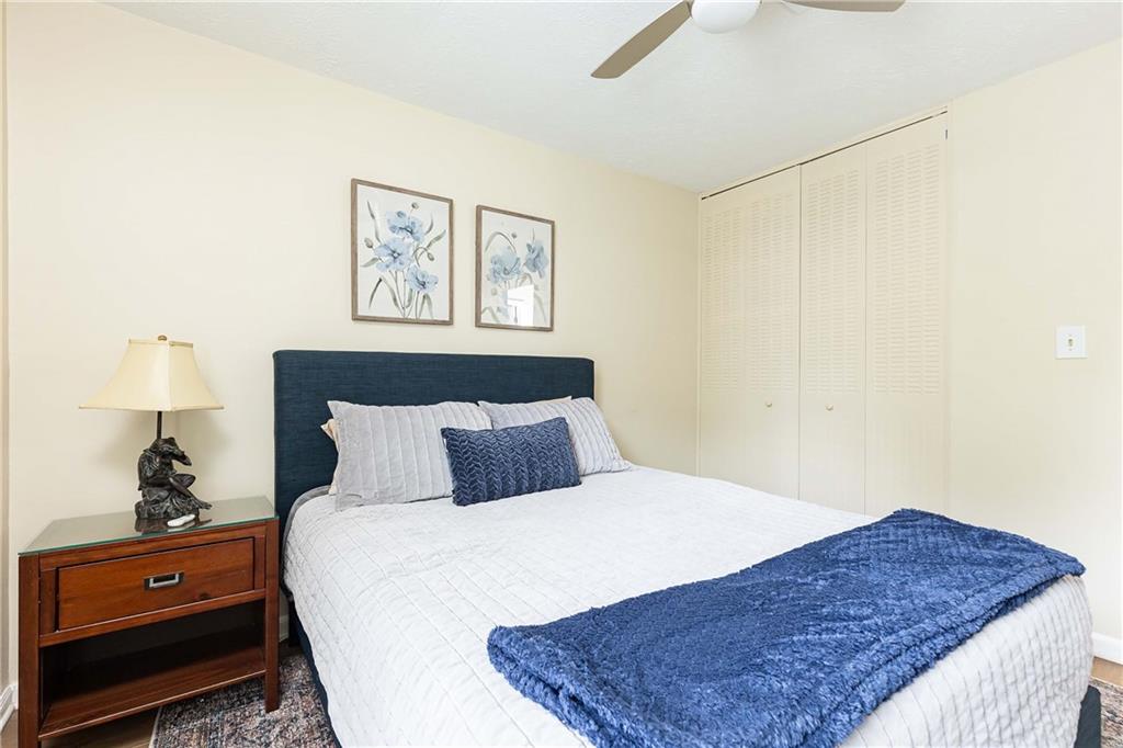 5 Middle Plantation Road Northwest, Unit 5 Atlanta, GA 30318 - Photo 19 of 33 a bedroom with a bed and a lamp on dresser
