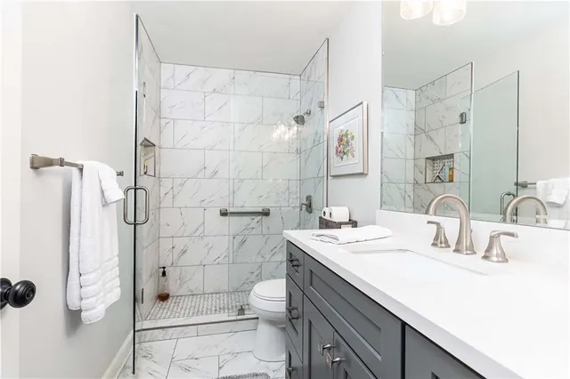 a bathroom with a double vanity sink toilet and shower