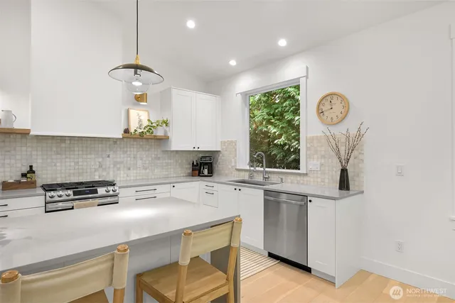 a kitchen with a stove a window and cabinets
