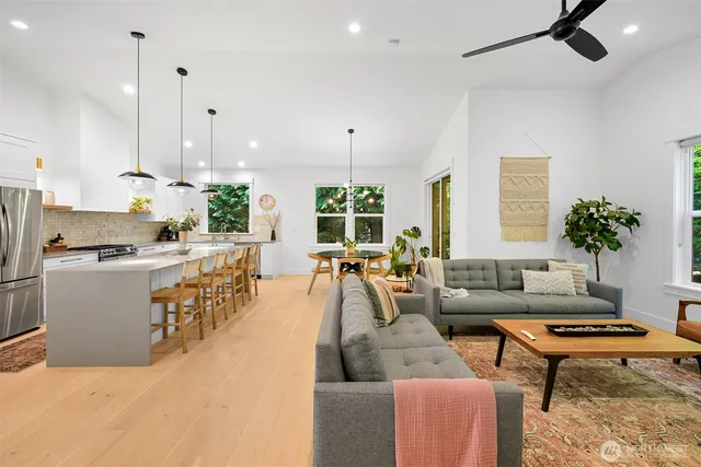 a living room with furniture kitchen view and a potted plant