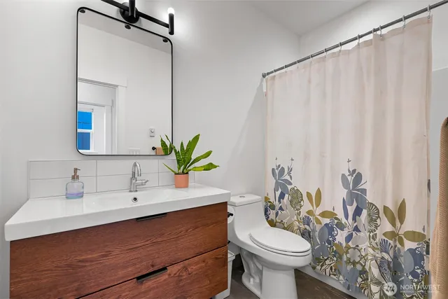 a bathroom with a sink vanity mirror and toilet